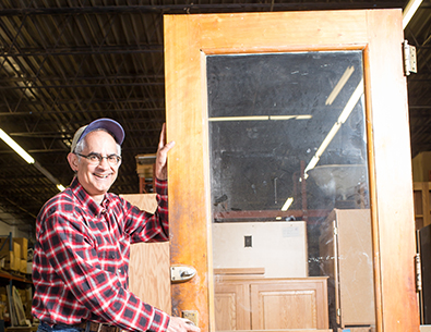 man holding wood door up