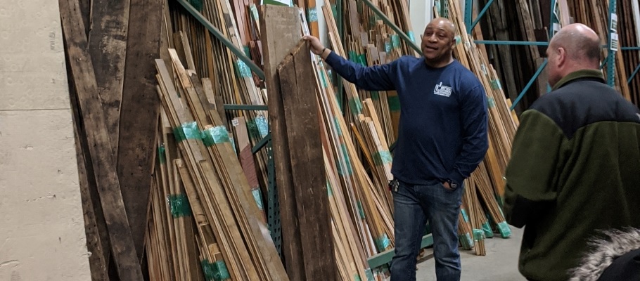 Man standing with stacks of reclaimed wood