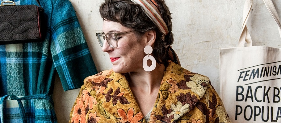 Woman trying on vintage jacket, looking left