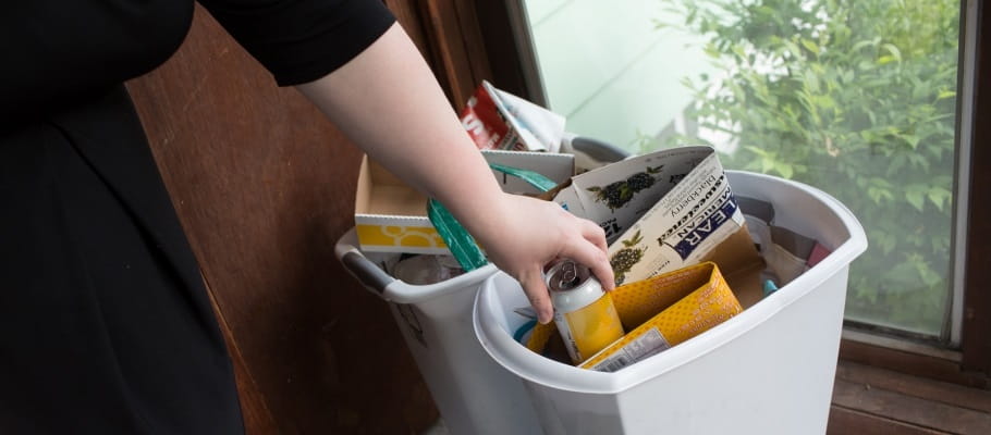 Putting a can in the recycling bin