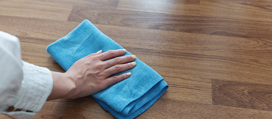person wiping table with a cloth