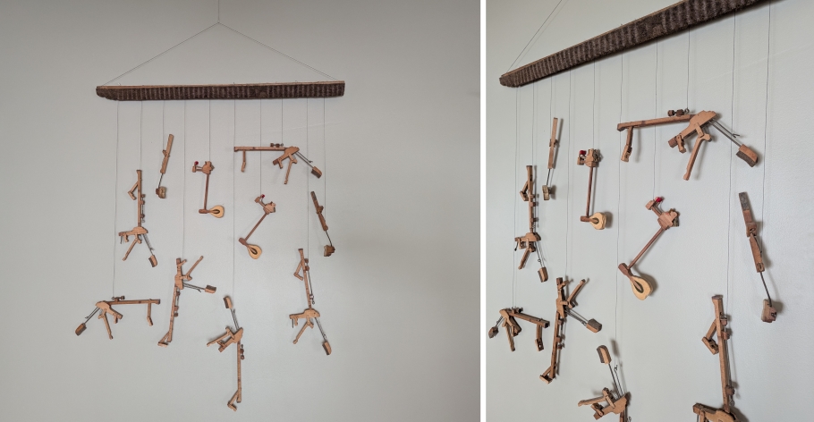 Hanging art piece on wall made of piano parts and wire