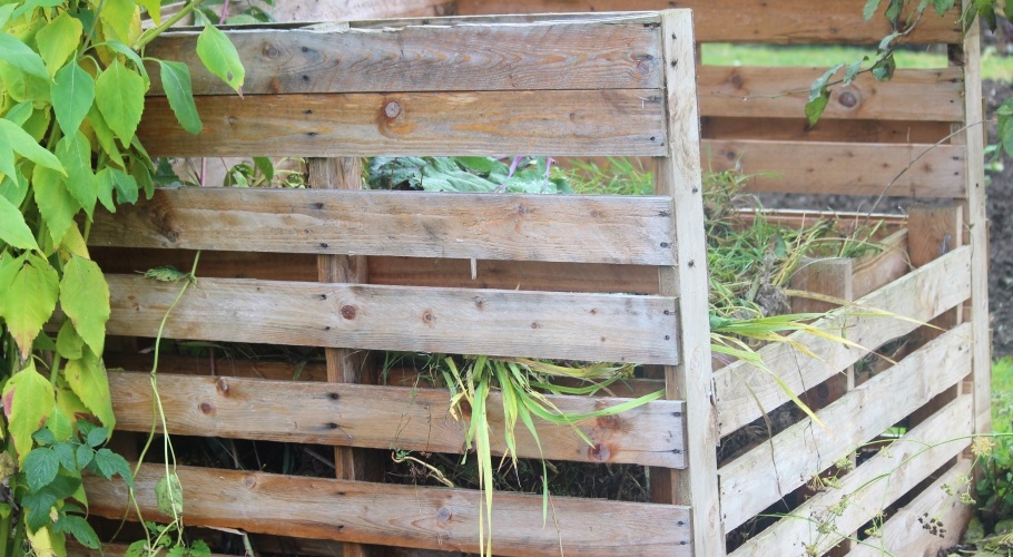 Compost bin in yard made of reused pallets