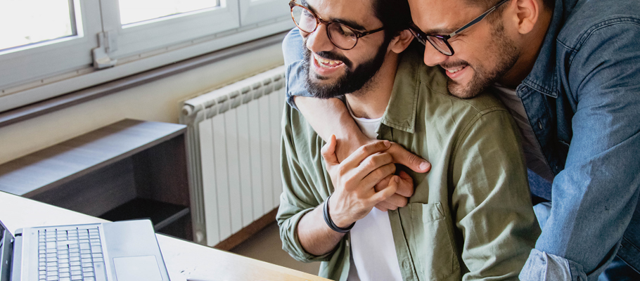 Couple smiling looking at computer