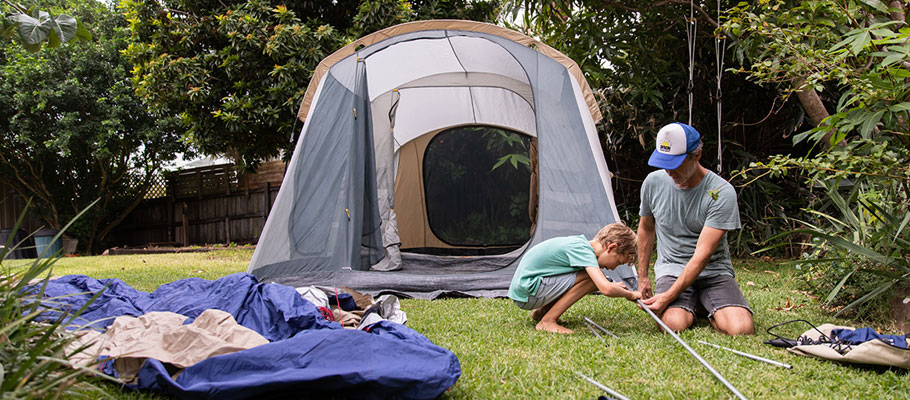 Father and son setting up a tent together