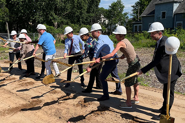 people outside shoveling dirt for the groundbreaking